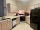 Functional kitchen featuring white cabinets, black appliances, and a double sink with ample natural light at 366 Jaybee Ave, Davenport, FL 33897