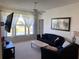 Cozy living room with comfortable seating, a ceiling fan, a large window, and a wall-mounted TV at 366 Jaybee Ave, Davenport, FL 33897