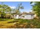 Backyard of home, featuring a green lawn and lush trees at 4410 Rossmore Dr, Orlando, FL 32810