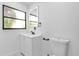 Bright bathroom boasts a modern vanity, framed mirror, and updated toilet with black hardware at 4410 Rossmore Dr, Orlando, FL 32810