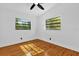 Clean bedroom features hardwood floors, white walls and trim, and natural light from the two windows at 4410 Rossmore Dr, Orlando, FL 32810