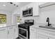 Well-lit kitchen with stainless steel appliances, white cabinets, and quartz countertops at 4410 Rossmore Dr, Orlando, FL 32810