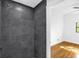 Walk-in shower featuring stylish dark gray tiling and modern fixtures at 4410 Rossmore Dr, Orlando, FL 32810