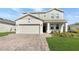 Charming two-story home with a brick driveway and a manicured lawn creates a welcoming curb appeal at 4623 Wandsworth Way, Davenport, FL 33837