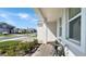 Inviting covered front porch with a cozy seating area, complemented by lush landscaping at 4623 Wandsworth Way, Davenport, FL 33837