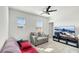 Cozy living room featuring plush seating, a modern ceiling fan, and a large screen TV at 4623 Wandsworth Way, Davenport, FL 33837