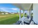 Covered patio area with comfortable seating, providing a relaxing outdoor living space overlooking the landscaped backyard at 4623 Wandsworth Way, Davenport, FL 33837