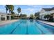 A beautiful community swimming pool with ample seating and palm trees at 4623 Wandsworth Way, Davenport, FL 33837
