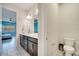 Bright bathroom featuring double sinks, a toilet, and a view into an adjacent bedroom at 4717 Weatherbell Rd, Winter Garden, FL 34787