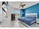 Cozy bedroom with a blue accent wall, ceiling fan, and ample natural light streaming through the window at 4717 Weatherbell Rd, Winter Garden, FL 34787