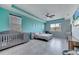 Spacious bedroom featuring modern ceiling fan, grey floors, and a crib for added convenience at 4717 Weatherbell Rd, Winter Garden, FL 34787