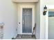 Close-up of a gray front door with a welcome mat and decorative accents at 4717 Weatherbell Rd, Winter Garden, FL 34787