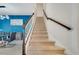 Carpeted stairway with white banister and wooden handrail, next to dining area with bright blue accent wall at 4717 Weatherbell Rd, Winter Garden, FL 34787