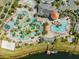 Aerial view featuring a resort-style pool with a lazy river, mini golf, and water slides near lake at 4721 Clock Tower Dr # 106, Kissimmee, FL 34746