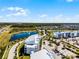 Modern apartment complex features lush lawns, a beautiful pond with a fountain, and convenient on-site parking with mature trees at 4721 Clock Tower Dr # 106, Kissimmee, FL 34746