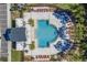 An aerial view showcasing the community pool with lounge chairs, pool house, and lush landscaping at 4721 Clock Tower Dr # 106, Kissimmee, FL 34746