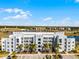 Modern condo building featuring balconies, palm trees, and a view of the lake and other buildings at 4721 Clock Tower Dr # 106, Kissimmee, FL 34746