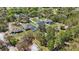 An aerial view showcasing homes with screened-in pools surrounded by lush green trees and landscaping at 4873 Old Oak Trl, St Cloud, FL 34771