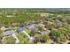 Aerial view showing houses with expansive yards and lush trees in a tranquil neighborhood setting near a lake at 4873 Old Oak Trl, St Cloud, FL 34771