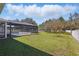 Expansive backyard featuring lush green grass and a screened-in pool, enclosed by a white privacy fence at 4873 Old Oak Trl, St Cloud, FL 34771