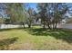 A large, well-manicured backyard featuring mature trees and an enclosing white fence for added privacy at 4873 Old Oak Trl, St Cloud, FL 34771