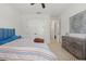 Bright bedroom with light-colored tile flooring, double doors, and a comfortable bed with an art piece above a dresser at 4873 Old Oak Trl, St Cloud, FL 34771