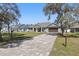 Charming single-story home with a beautifully landscaped front yard and a brick driveway on a sunny day at 4873 Old Oak Trl, St Cloud, FL 34771
