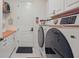 Convenient laundry room with modern washer and dryer, ample counter space, and storage cabinets at 4873 Old Oak Trl, St Cloud, FL 34771