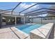 Stunning screened-in pool area with stone pavers, outdoor dining, and access to the home's interior at 4873 Old Oak Trl, St Cloud, FL 34771