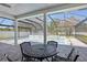 Screened-in pool area with outdoor dining and lush landscaping, perfect for entertaining at 4873 Old Oak Trl, St Cloud, FL 34771