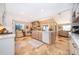 Modern kitchen features an island with seating, travertine floors, and views of the living room at 6051 Twin Lakes Dr, Oviedo, FL 32765