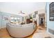 Bright living room boasts a curved sofa, hardwood floors, and large windows with views at 6051 Twin Lakes Dr, Oviedo, FL 32765