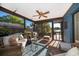 The screened-in patio offers a view of the lake with comfortable seating and a ceiling fan at 6051 Twin Lakes Dr, Oviedo, FL 32765