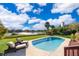 Backyard with in-ground pool and scenic lake view, surrounded by mature landscaping and outdoor furniture at 6051 Twin Lakes Dr, Oviedo, FL 32765