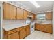 Functional kitchen featuring wooden cabinets, laminate countertops, and updated white appliances at 612 California Ave, St Cloud, FL 34769