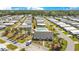 Overhead shot of a well-planned community with a shared pool, clubhouse, and neatly arranged residences amid lush greenery at 6462 Hollyberry Ne Ln, Winter Haven, FL 33881