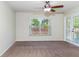 Cozy bedroom with neutral carpet, ceiling fan, and sliding glass doors to the outside at 6495 Fall St, St Cloud, FL 34771