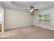 Bedroom with neutral carpet and a ceiling fan has great light from a large window at 6495 Fall St, St Cloud, FL 34771