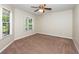 Bedroom features neutral carpet, a ceiling fan, and nice natural light from two windows at 6495 Fall St, St Cloud, FL 34771