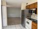 Functional kitchen features stainless steel appliances, tiled floor, and wood cabinets at 723 Michigan Ct # 3, St Cloud, FL 34769