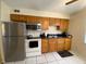 Efficient kitchen with stainless steel refrigerator and wooden cabinets at 723 Michigan Ct # 3, St Cloud, FL 34769