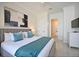 Well-lit bedroom featuring a comfortable king bed, modern art, and an adjacent bathroom at 7570 Excitement Dr, Reunion, FL 34747