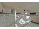 Bright dining room features a glass table and modern white chairs, seamlessly blending into the living area at 7570 Excitement Dr, Reunion, FL 34747