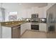 Modern kitchen with white cabinets, stainless steel appliances, and granite countertops at 7570 Excitement Dr, Reunion, FL 34747