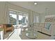 Bright living room boasts large windows overlooking the outdoor patio area and comfortable neutral furniture at 7570 Excitement Dr, Reunion, FL 34747