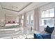 Spacious main bedroom featuring a canopy bed, sitting area, and access to a private balcony at 7570 Excitement Dr, Reunion, FL 34747