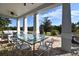 The covered patio offers a luxurious outdoor dining and seating area with expansive views of the lush landscape at 7570 Excitement Dr, Reunion, FL 34747