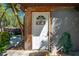 Home's welcoming back door with a 'Welcome' sign, enhanced by a rustic setting and exterior details at 815 Kentucky Ave, St Cloud, FL 34769