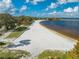 Aerial view of a sandy beach with volleyball nets next to a lakeside walking path with trees at 815 Kentucky Ave, St Cloud, FL 34769