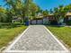 Well-maintained driveway with brick pavers leading to a private gated home with lush landscaping at 815 Kentucky Ave, St Cloud, FL 34769